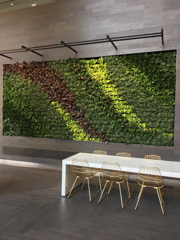 Modern office with a lush green wall, creating a refreshing atmosphere by Oasis Plantscaping